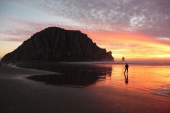 A photographer on the beach photographing the sunset