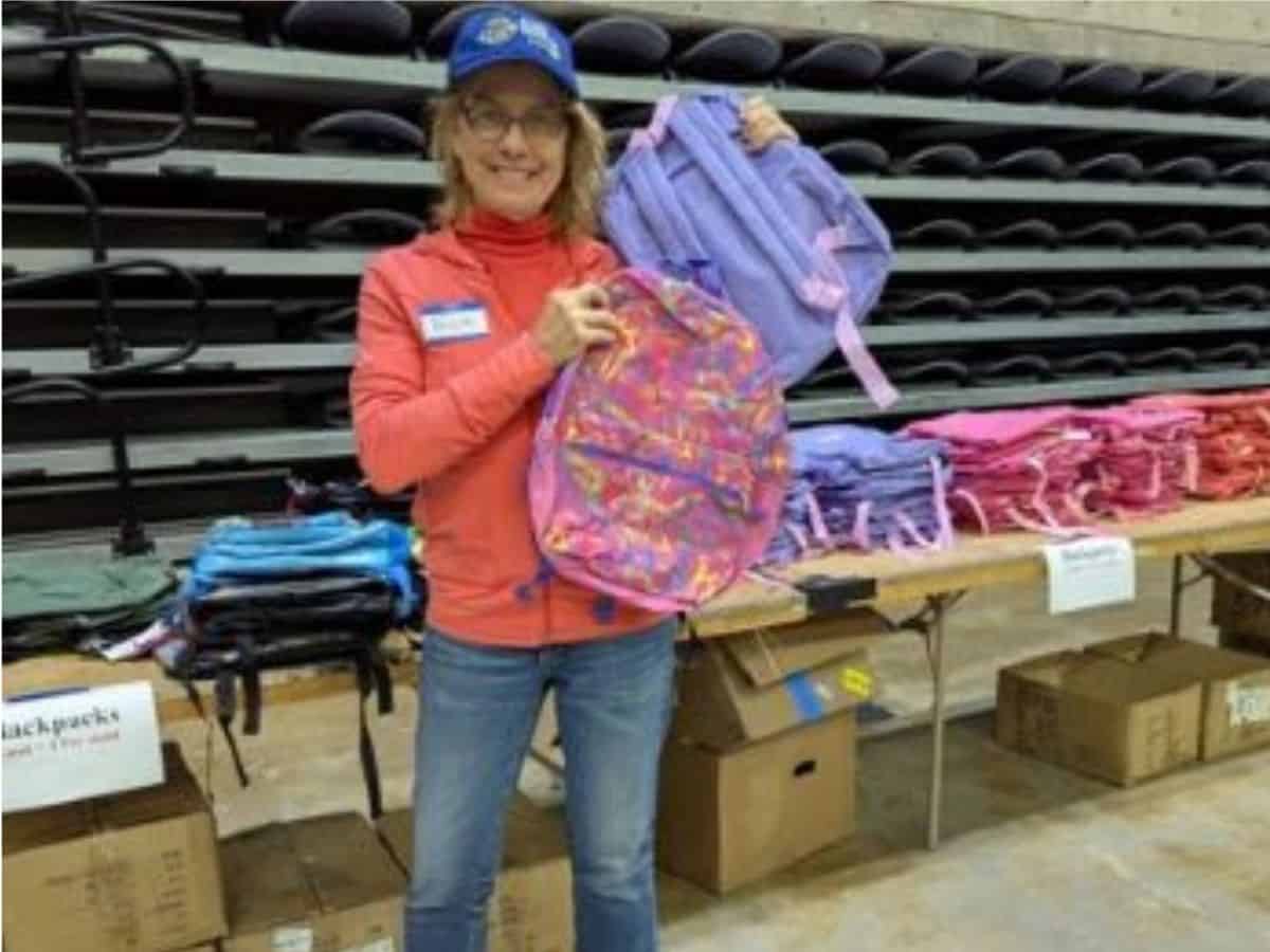 OpsSchoolSupply A Global Travelers member with backpacks to donate to a school